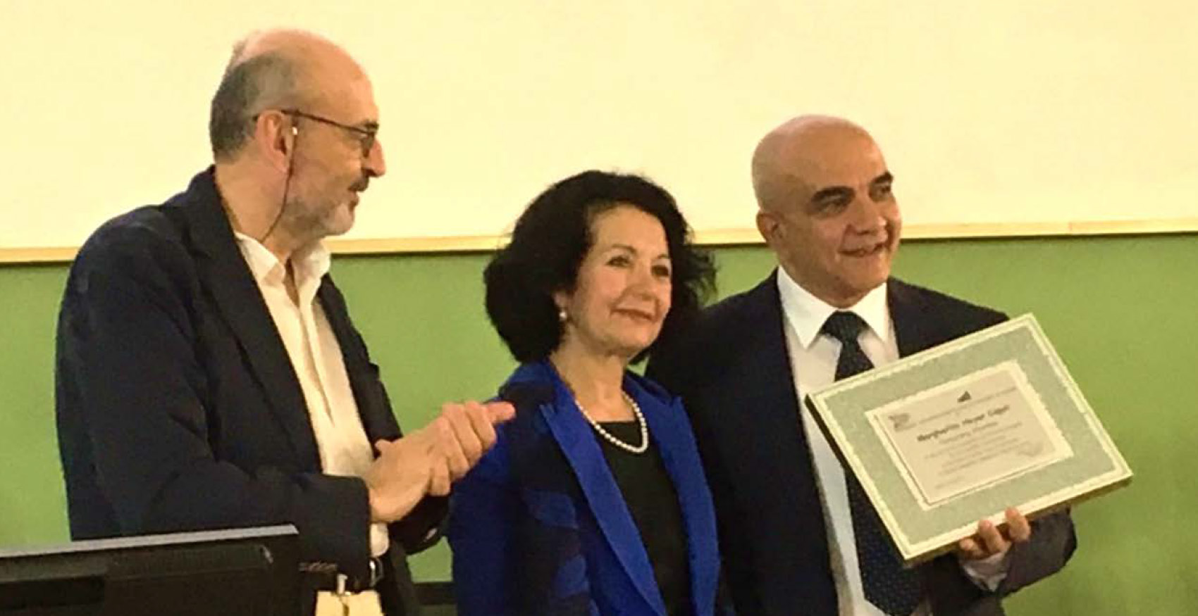 At this year's annual conference of the American Association of Teachers of Italian (AATI) held at the University of Cagliari in Cagliari, Italy, our own Professor Margherita Heyer-Caput was awarded with the AATI Honorary Membership. She was presented the membership plaque by Professor Salvatore Bancheri, Chair of the Department of Italian Studies at the University of Toronto and President Emeritus of the AATI. In announcing the honor, he read the text of the plaque: "The American Association of Teachers of Italian awards to Margherita Heyer-Caput Honorary Membership of the AATI for her indelible contribution to the field of Italian and, in particular, of Italian-American Studies in North America." Upon receiving the honor, Professor Heyer-Caput delivered the event's keynote address.
