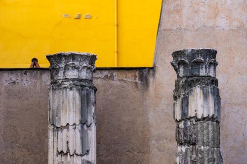 ancient columns near a yellow backdrop
