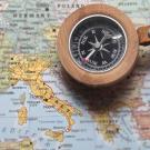 A compass on top of a map of Italy