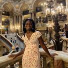 A woman stands in an elaborate marble gallery